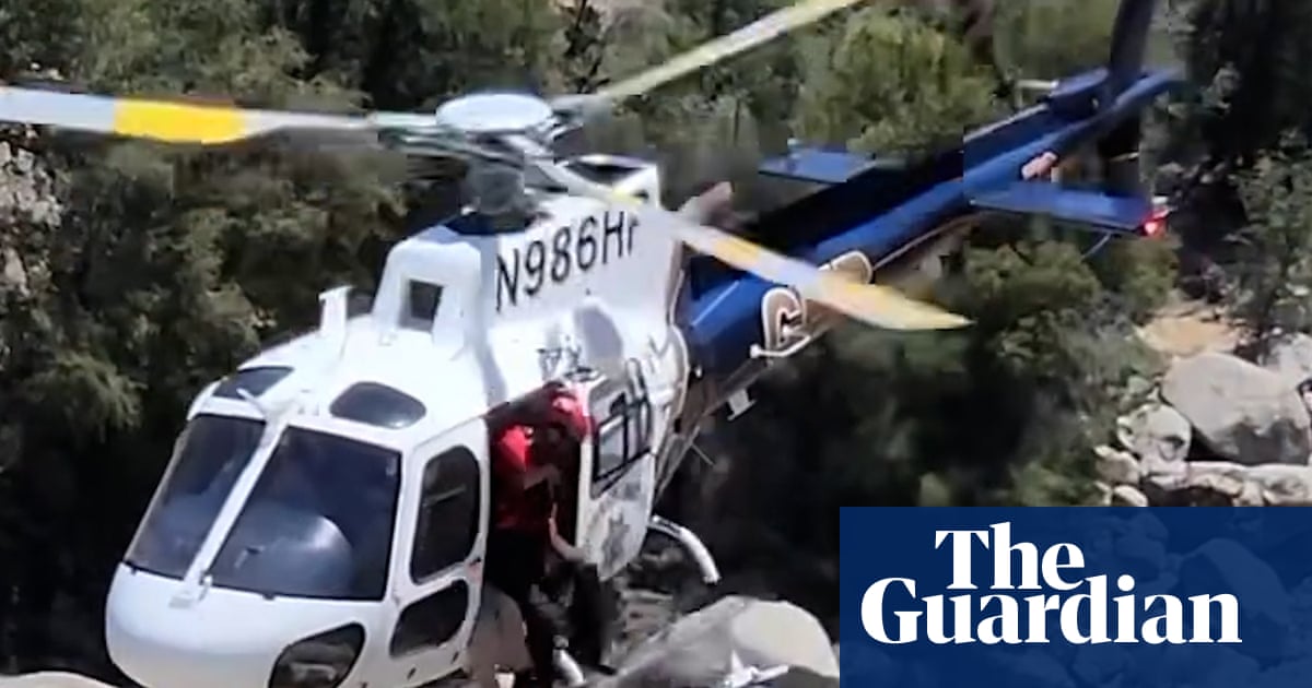 Police rescue man trapped behind waterfall in California – video
