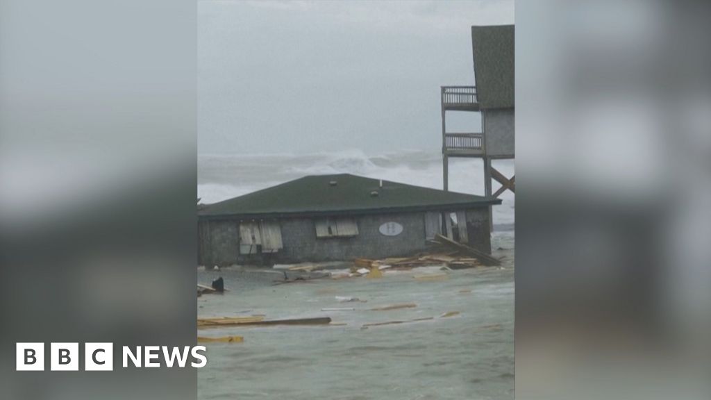 Watch: Moment houses on stilts topple into the sea