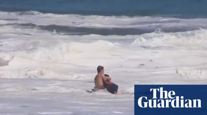 Teen lifeguard struggles to save boy from massive waves in California - video